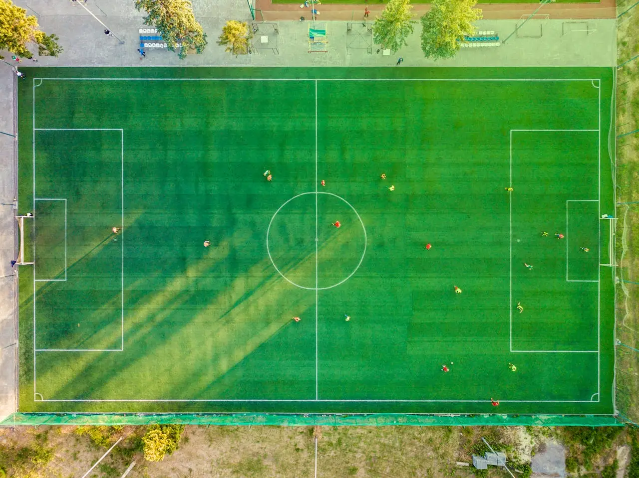 services-04 Aerial shot of a soccer game with players on a vibrant green field.