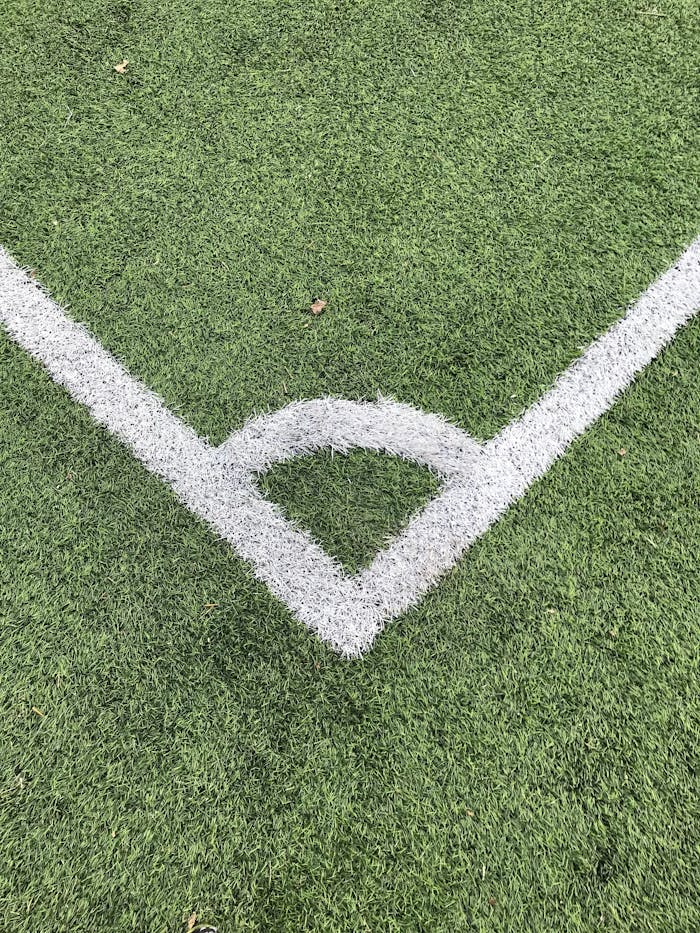 our-story Detailed close-up of a white corner line on a green soccer field turf.